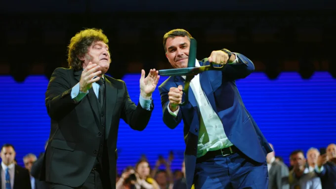 O presidente da Argentina, Javier Milei, posa ao lado de Flávio Bolsonaro.