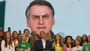 O candidato Flávio Bolsonaro assistindo o vídeo de Bolsonaro feito com IA